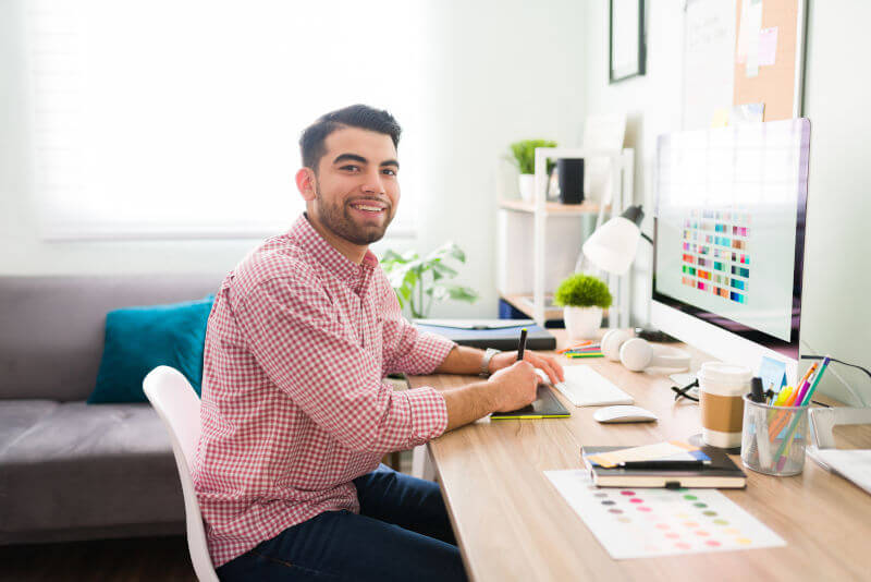 Happy young Latin designer using a tablet